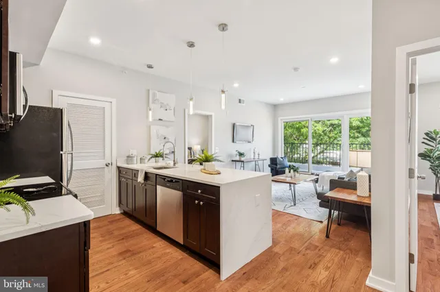 a kitchen with a stove a refrigerator a sink dishwasher with a dining table and chairs with wooden floor