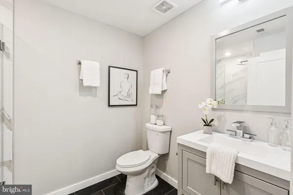 a bathroom with a sink toilet and mirror