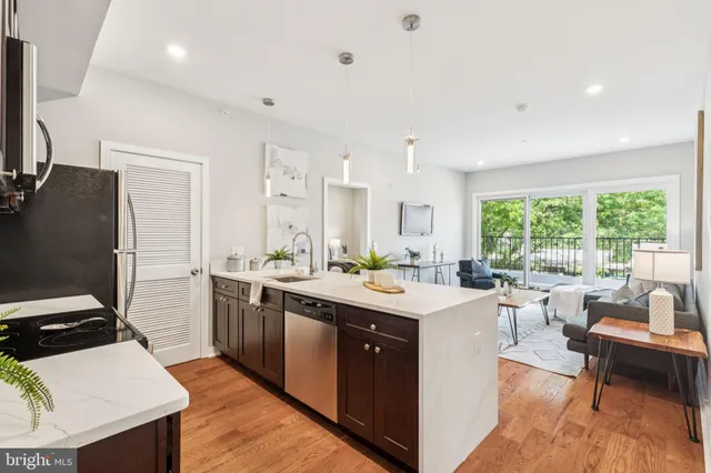 a kitchen with a sink stove and chairs