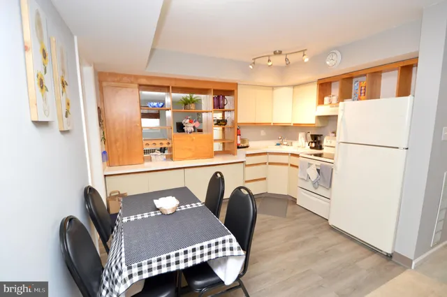 a kitchen with a table chairs refrigerator and a sink
