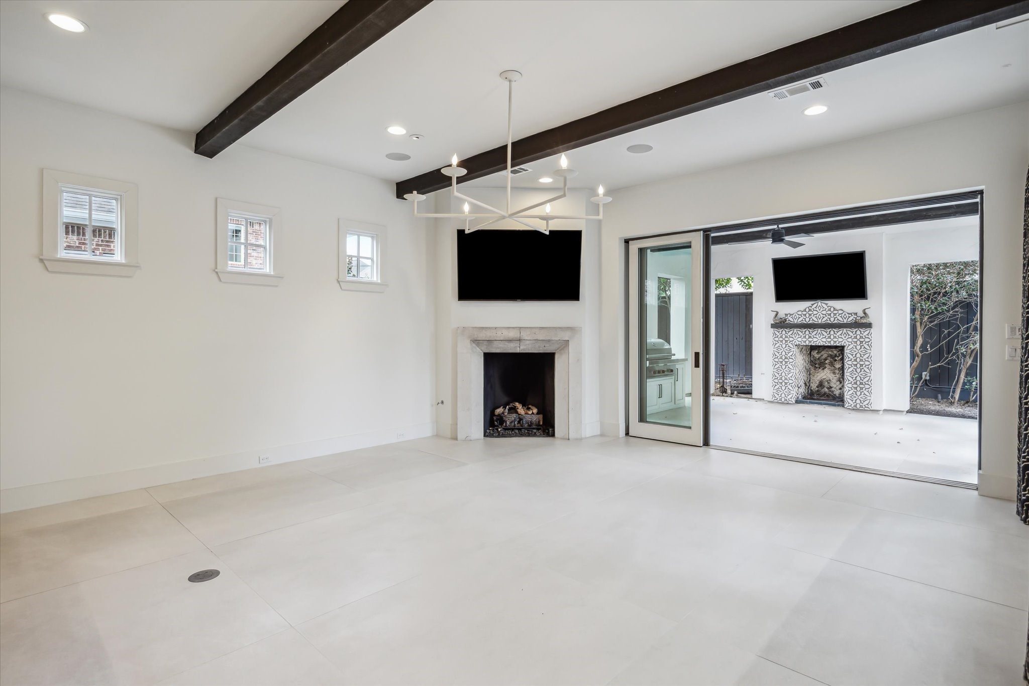 3214 Westheimer Road Houston, TX 77098 - Photo 12 of 39 Stained wood beam ceilings and a gas log fireplace enhance the inviting ambiance of this spacious room. Natural light floods the space, highlighting its luxurious finishes and thoughtful design.