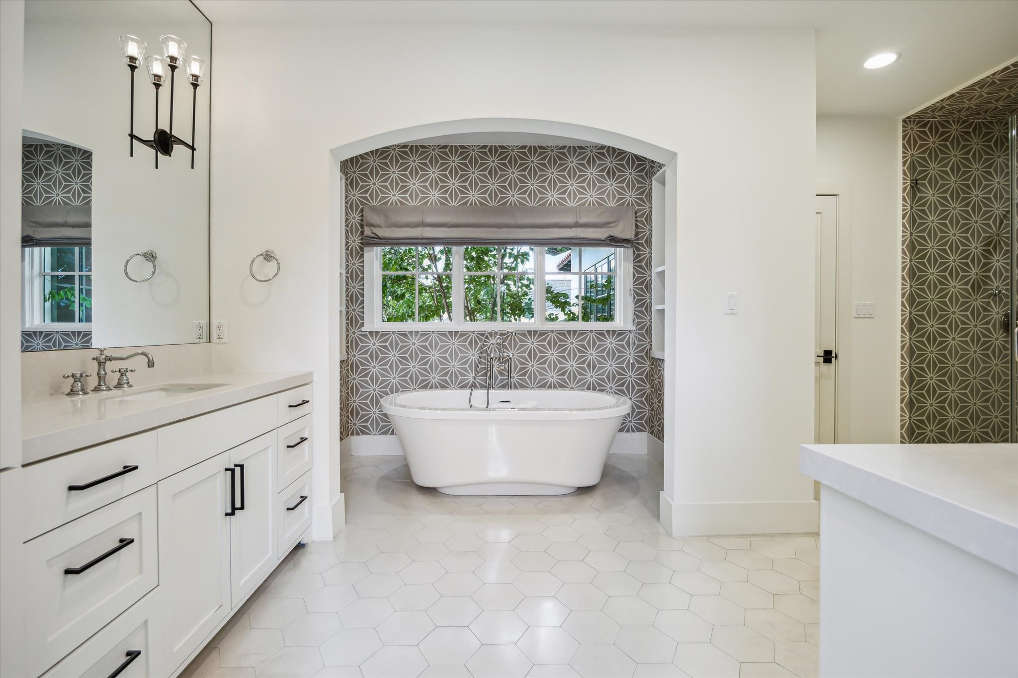 3214 Westheimer Road Houston, TX 77098 - Photo 27 of 39 A luxurious soaking tub takes center stage, surrounded by gray and white cement tile walls and inset shelving. This spa-like feature invites relaxation and indulgence in the comfort of your own home.