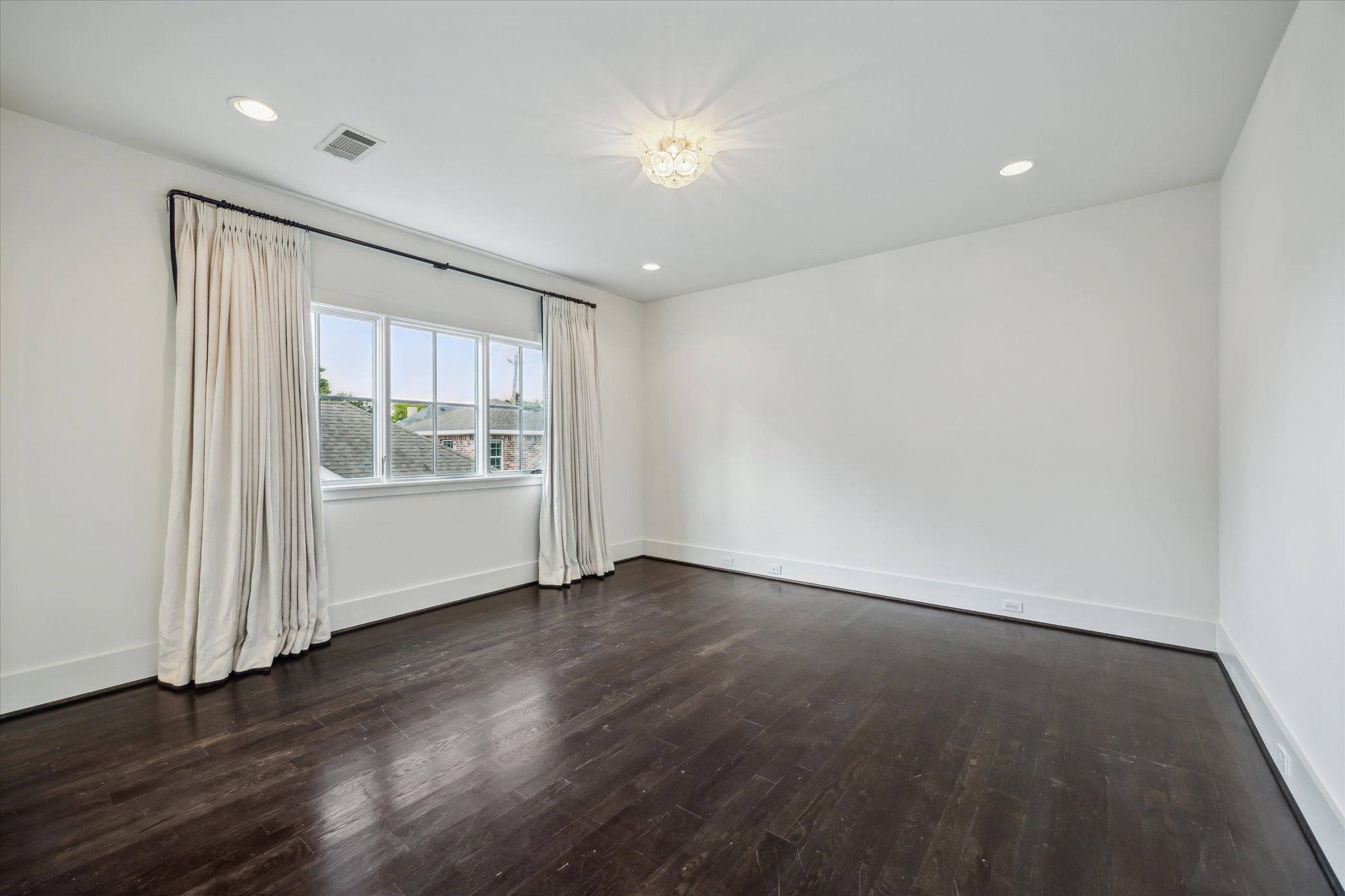 3214 Westheimer Road Houston, TX 77098 - Photo 34 of 39 Warm hardwood floors and custom lighting define this west-facing bedroom, creating a serene and inviting ambiance. Designer window coverings and spacious proportions add to its charm. This room offers both comfort and style.