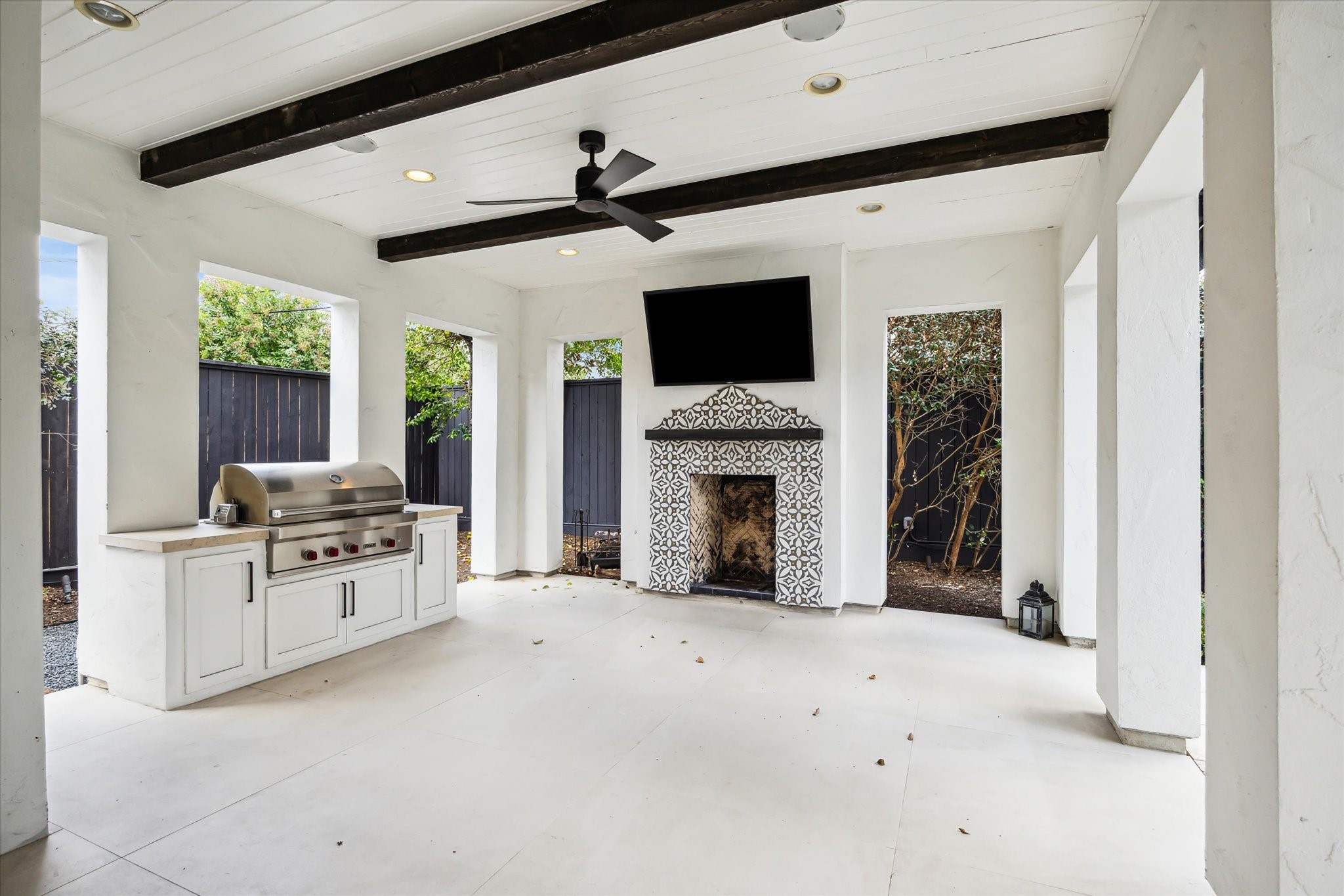 3214 Westheimer Road Houston, TX 77098 - Photo 37 of 39 The covered patio, featuring a gas and wood-burning fireplace, sets the scene for cozy outdoor entertaining year-round. The fully equipped summer kitchen includes a Wolf grill for hosting gatherings of all sizes.