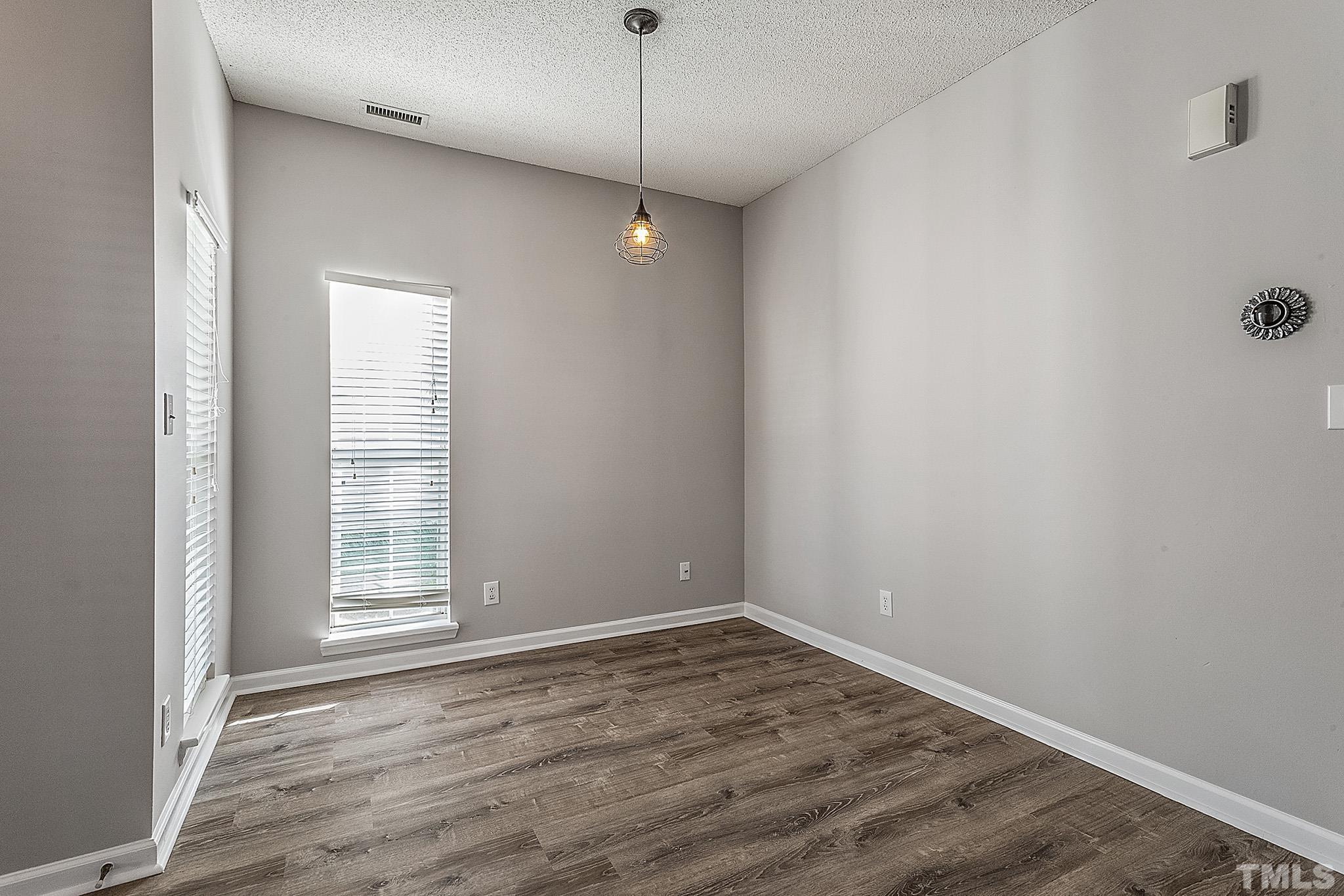 121 Marleton Way Holly Springs, NC 27540 - Photo 11 of 26 a view of an empty room with wooden floor and a window