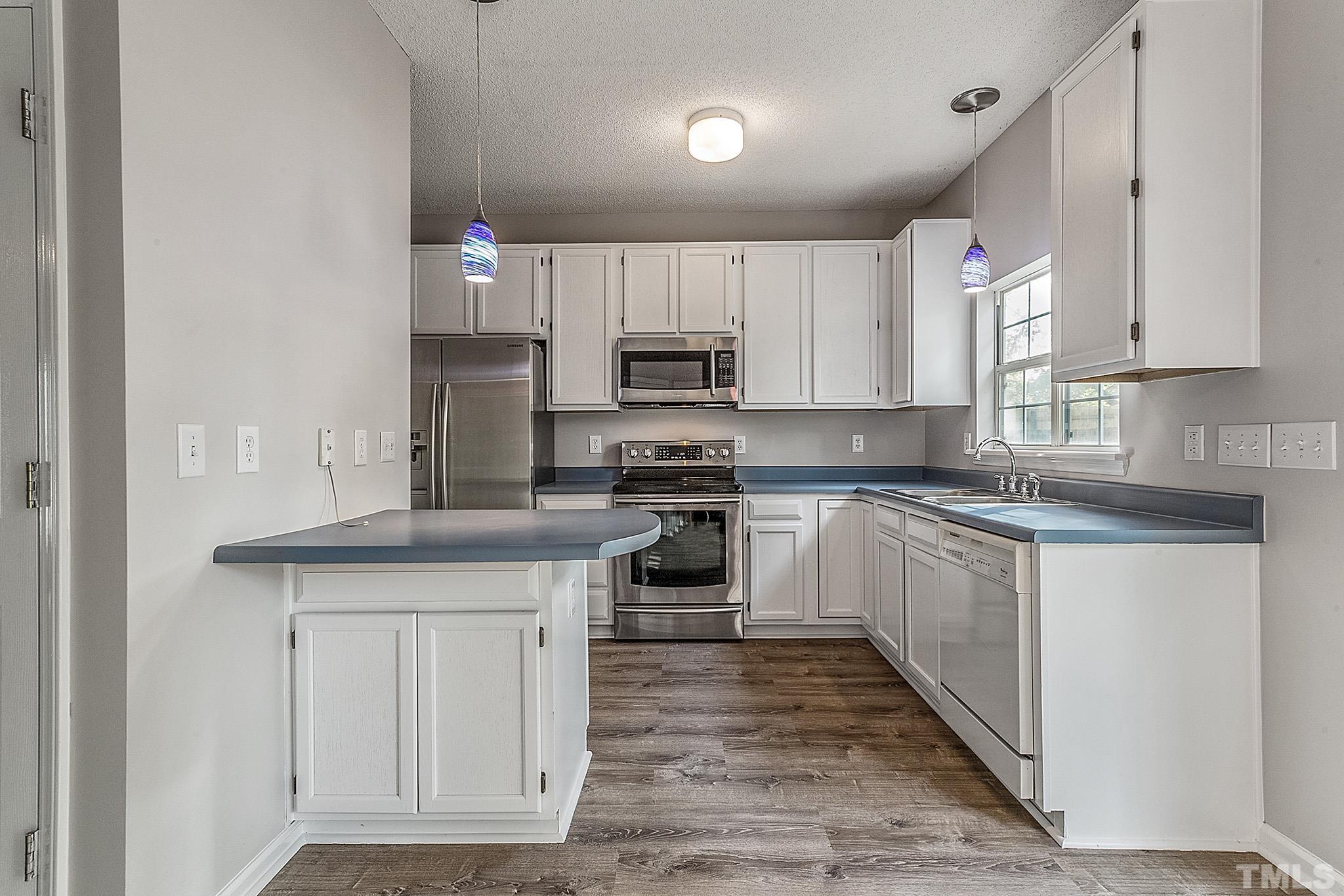 121 Marleton Way Holly Springs, NC 27540 - Photo 16 of 26 a kitchen with granite countertop white cabinets and stainless steel appliances