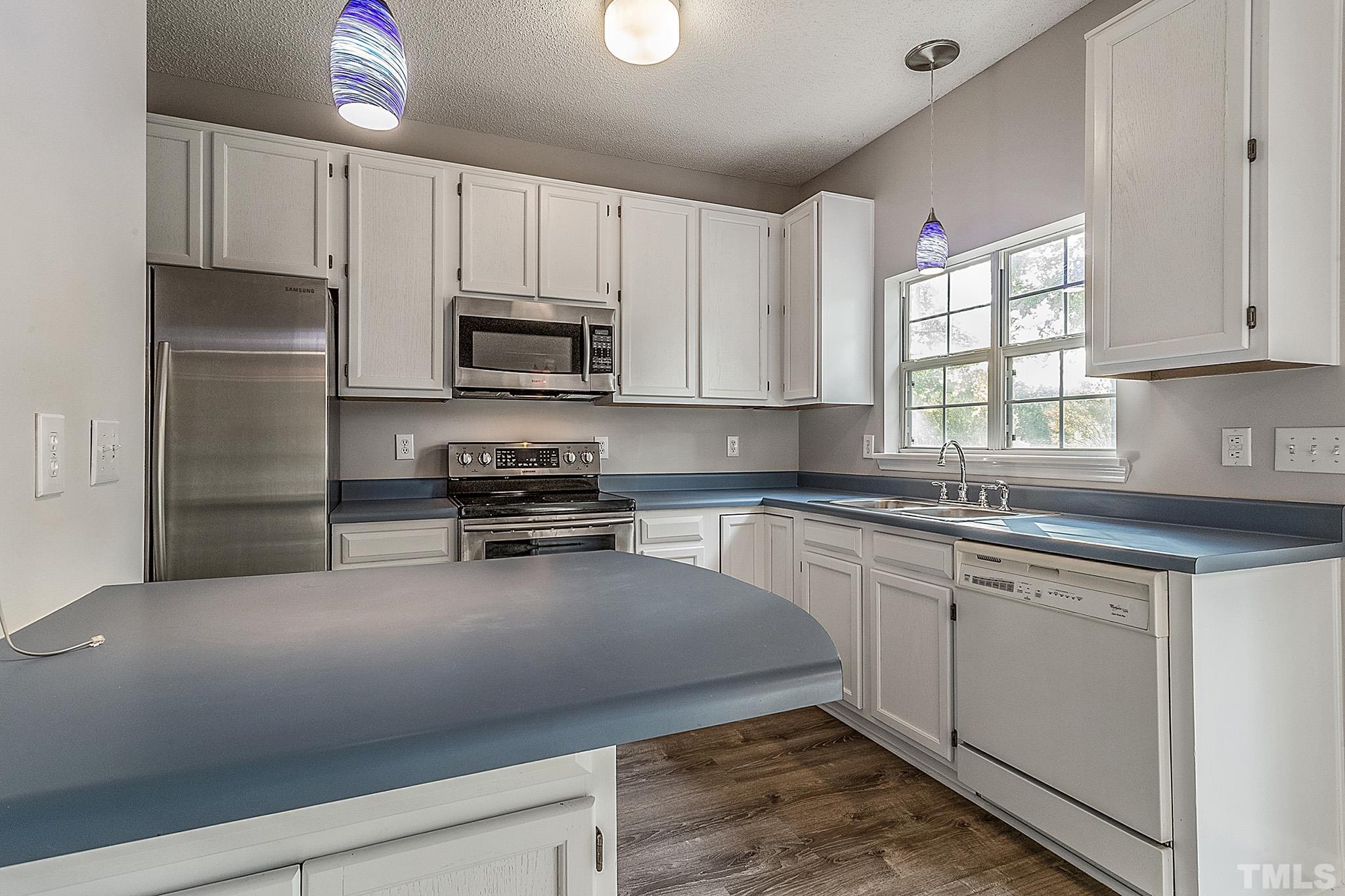 121 Marleton Way Holly Springs, NC 27540 - Photo 17 of 26 a kitchen with granite countertop a refrigerator sink and microwave