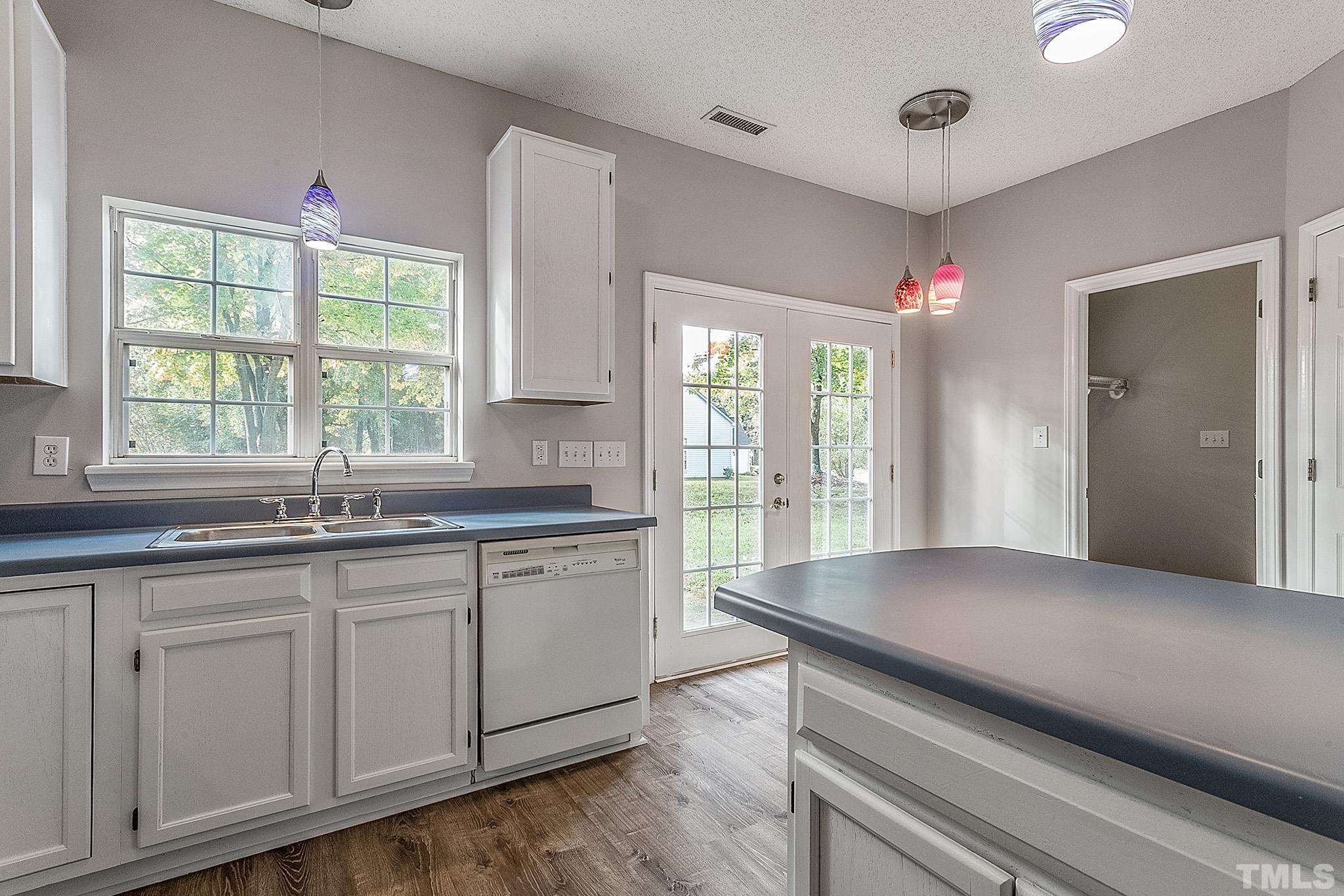 121 Marleton Way Holly Springs, NC 27540 - Photo 18 of 26 a open kitchen with granite countertop a sink and dishwasher with wooden floor