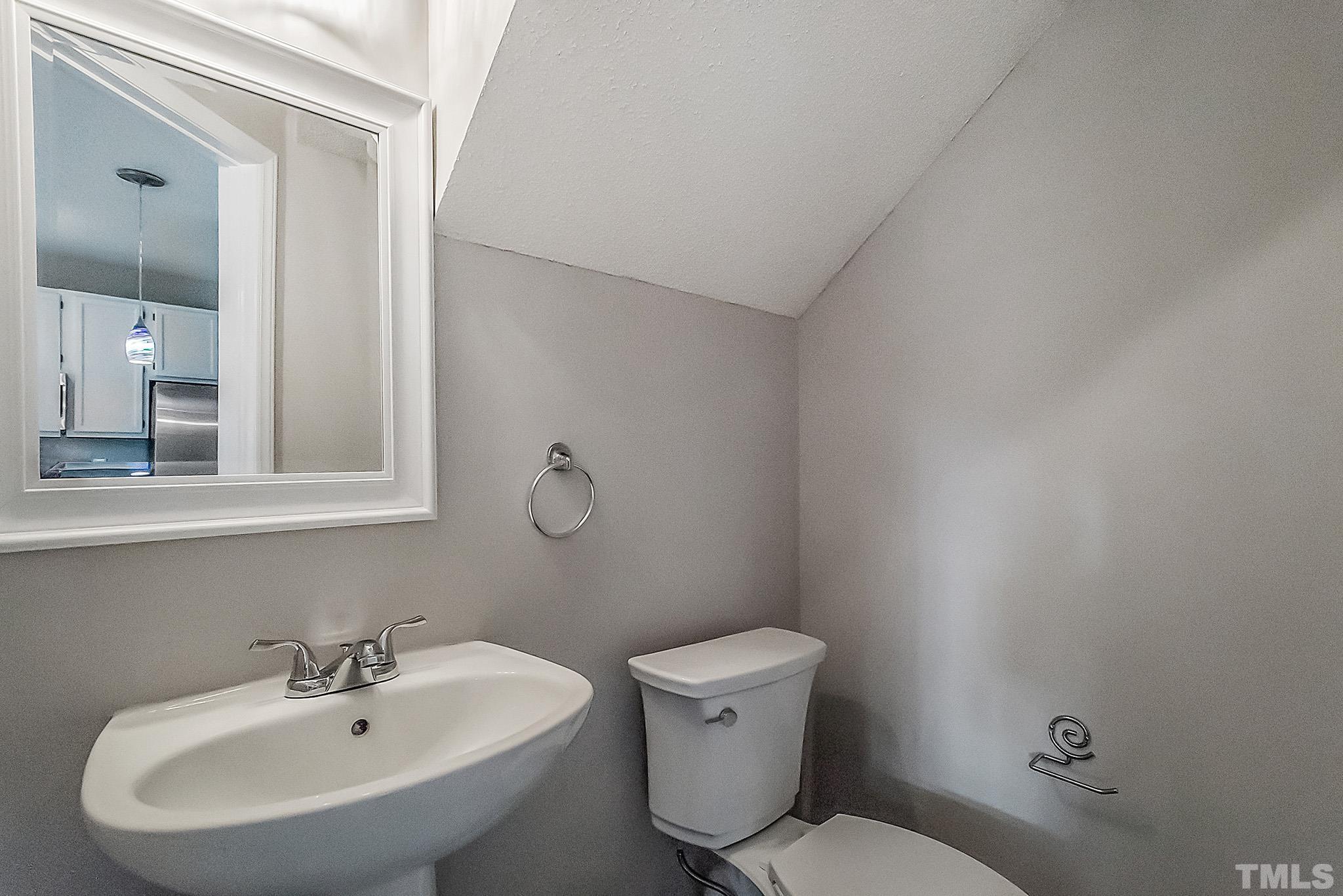 121 Marleton Way Holly Springs, NC 27540 - Photo 20 of 26 a bathroom with a sink mirror and toilet