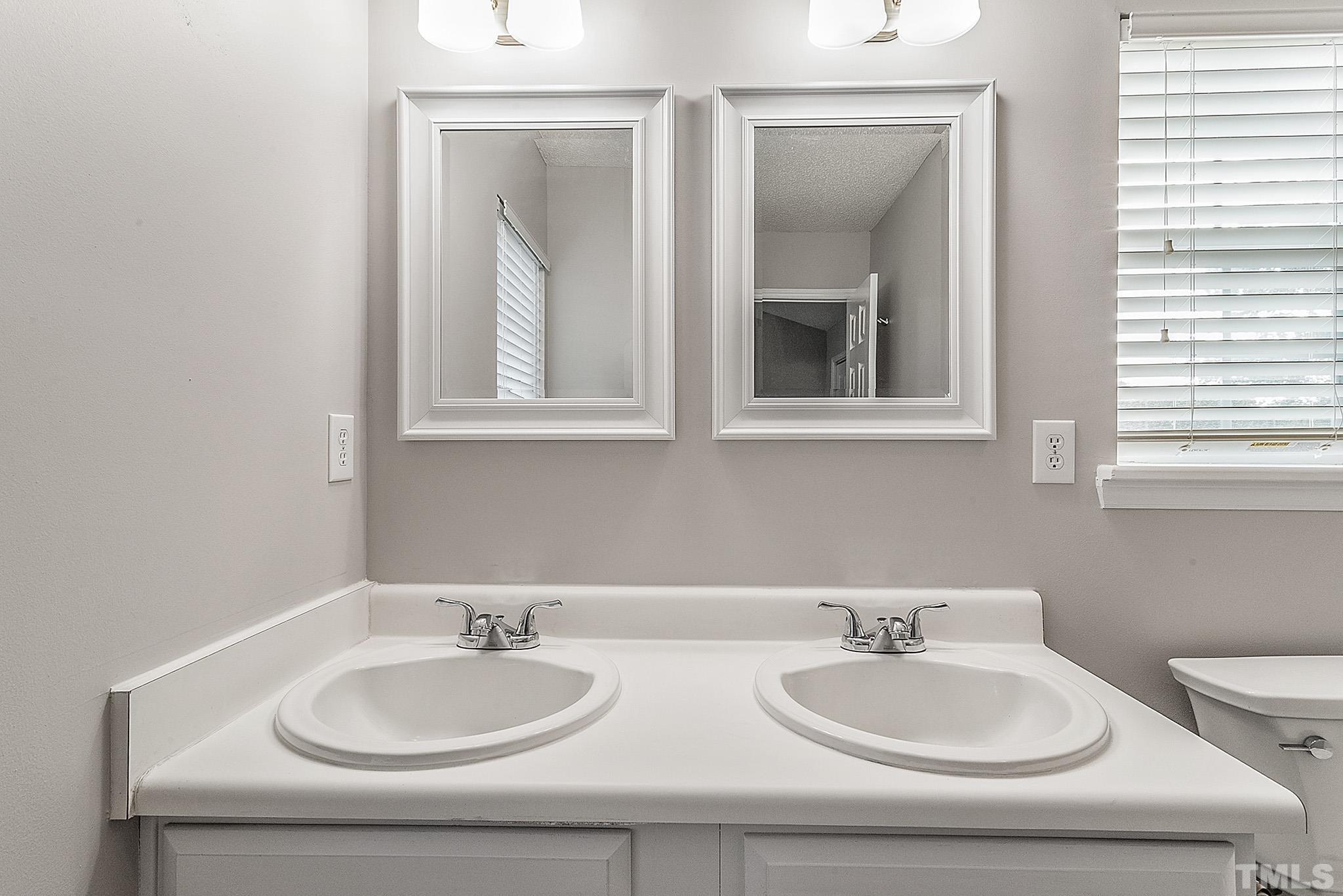 121 Marleton Way Holly Springs, NC 27540 - Photo 24 of 26 a bathroom with 2 sink and a mirror