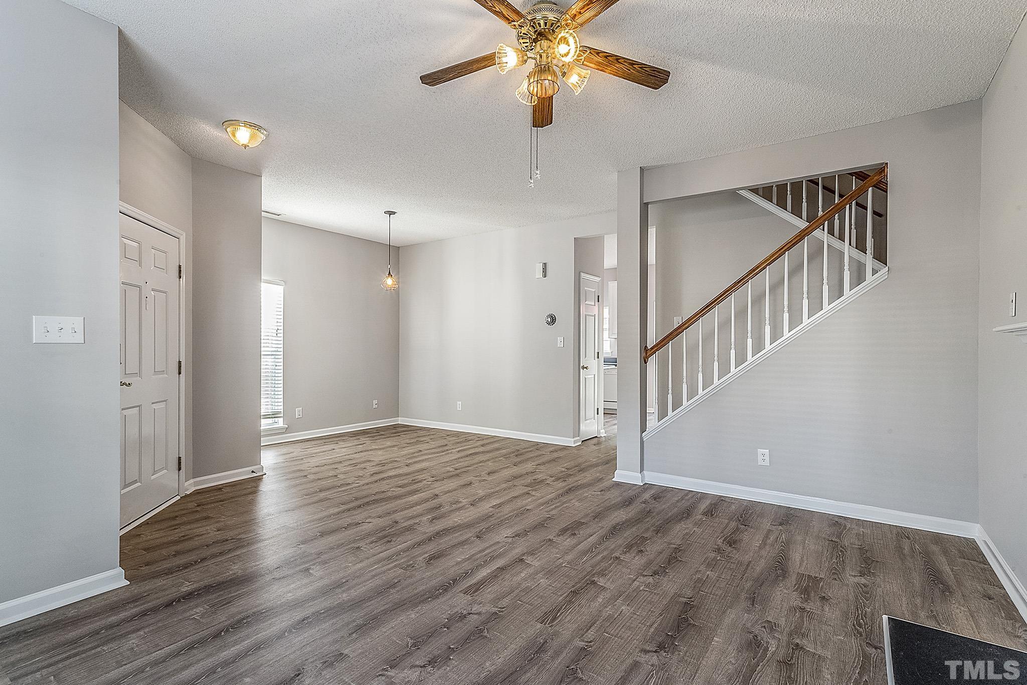 121 Marleton Way Holly Springs, NC 27540 - Photo 9 of 26 a view of an empty room with wooden floor and a ceiling fan