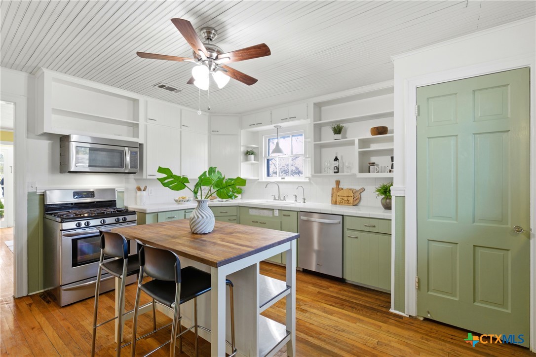1506 Grace Street Taylor, TX 76574 - Photo 11 of 22 a kitchen with a table chairs refrigerator and cabinets