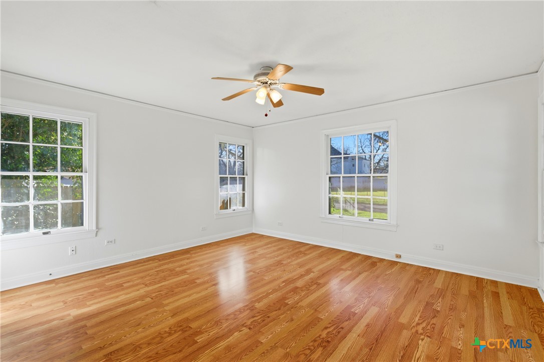 1506 Grace Street Taylor, TX 76574 - Photo 9 of 22 a view of an empty room with a window and wooden floor