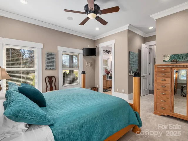 a bedroom with a large bed and a chandelier