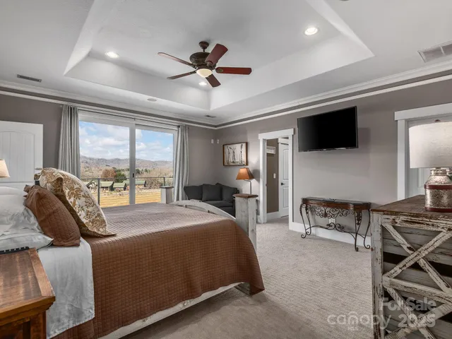 a bed room with a bed a television and a large window