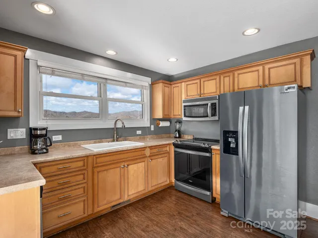 a kitchen with stainless steel appliances granite countertop a sink stove and refrigerator