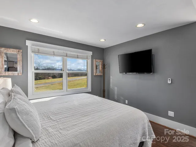 a bedroom with a bed and a flat screen tv