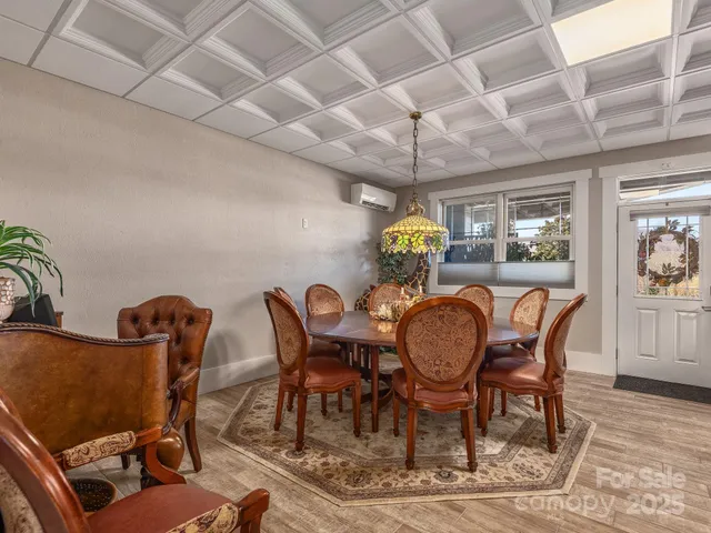 a dining room with furniture a chandelier and wooden floor