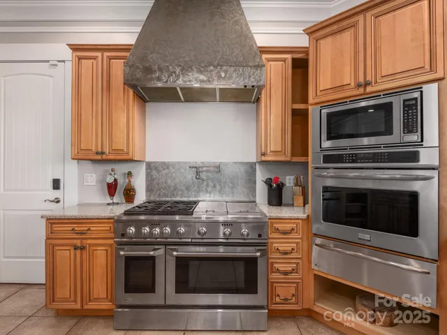 a kitchen with stainless steel appliances granite countertop a stove microwave and oven