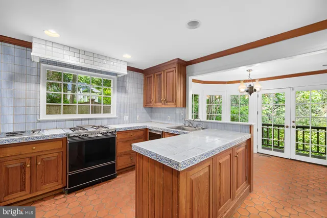 a kitchen with a stove sink and window
