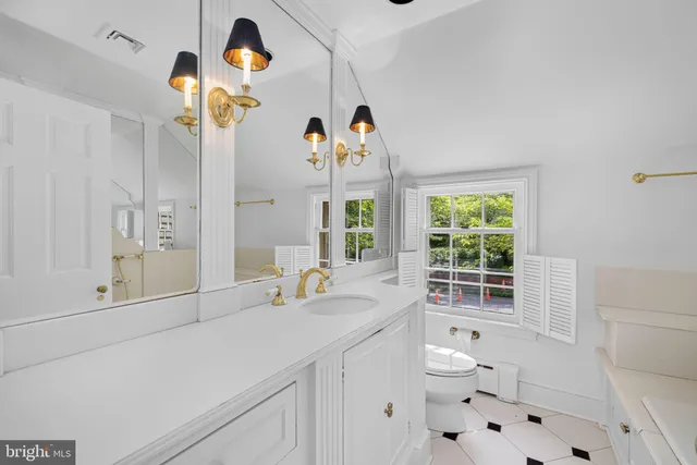 a bathroom with a sink a toilet and a window