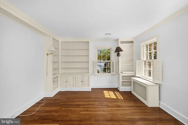 a view of an empty room with window and wooden floor