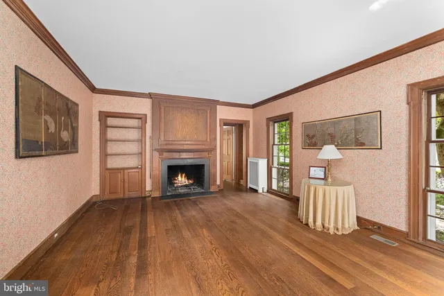 a view of a livingroom with wooden floor and a fireplace