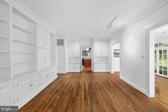 a view of empty room with wooden floor and window