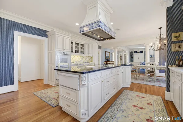 a kitchen with stainless steel appliances granite countertop a stove and white cabinets