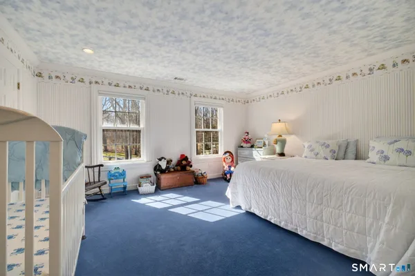 a spacious bedroom with a bed fireplace and window