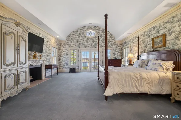 a spacious bedroom with a bed and a television