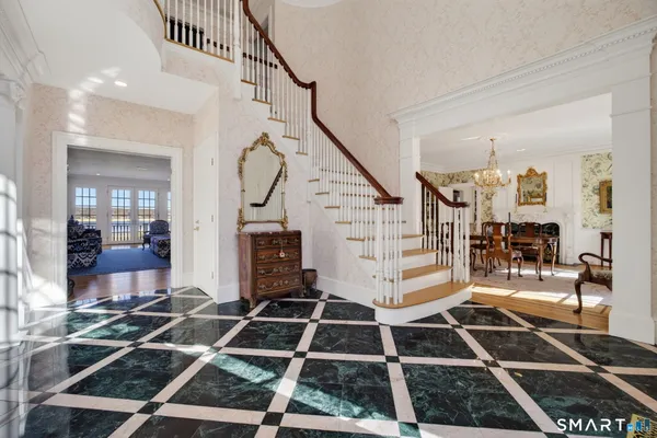 a room with lots of white furniture and a rug