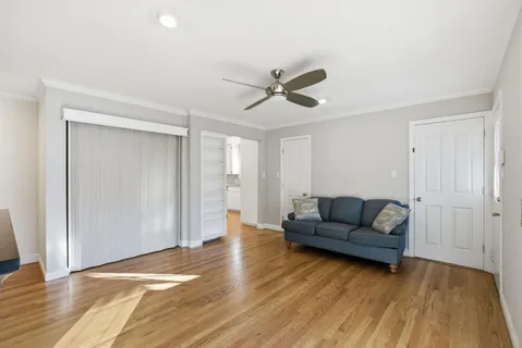 a view of an empty room with wooden floor and window