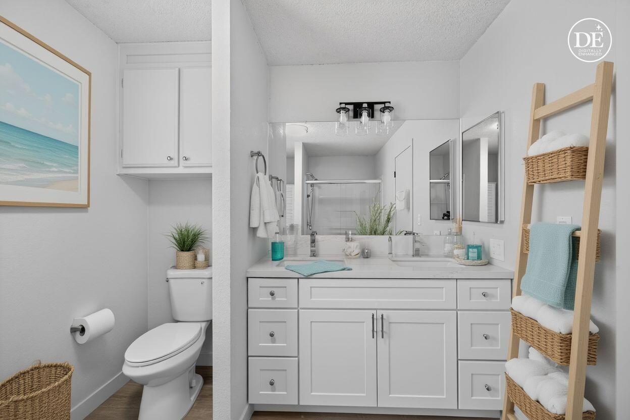 15181 Van Buren Boulevard, Unit 102 Riverside, CA 92504 - Photo 22 of 29 a bathroom with a granite countertop toilet sink and mirror
