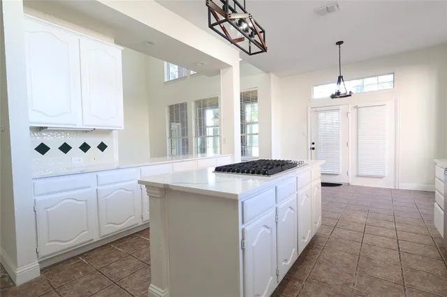 a kitchen with granite countertop a sink stove and cabinets