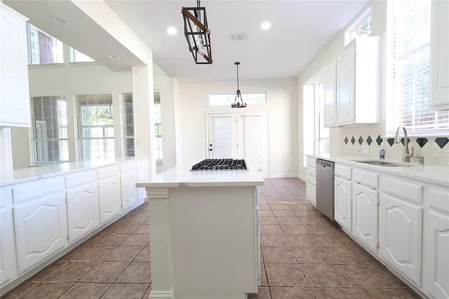 a large kitchen with a sink and cabinets