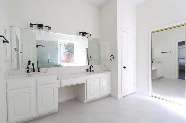 a spacious bathroom with a double vanity sink a mirror and a bathtub