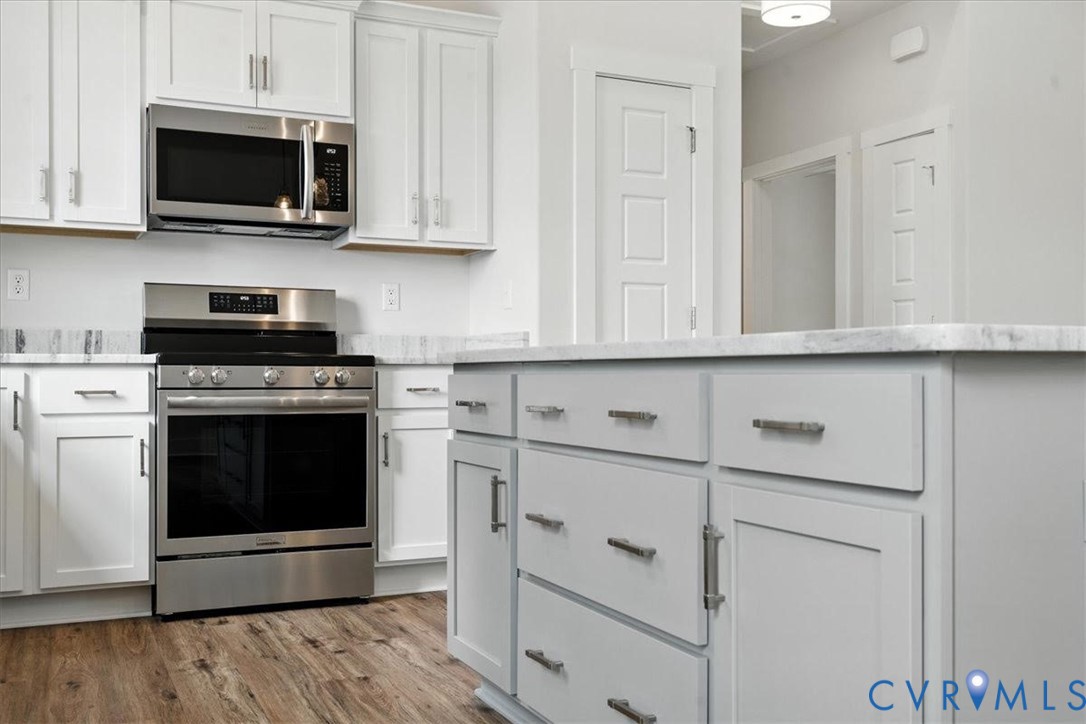 3898 Horseshoe Road Appomattox, VA 24522 - Photo 12 of 32 a kitchen with stainless steel appliances granite countertop white cabinets and a stove top oven