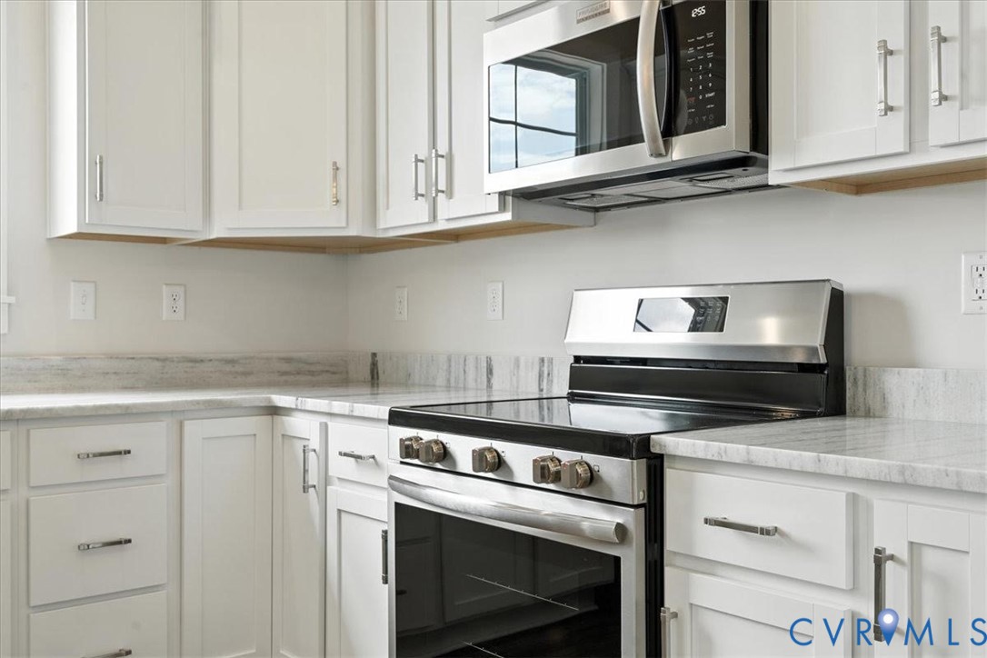 3898 Horseshoe Road Appomattox, VA 24522 - Photo 17 of 32 a kitchen with stainless steel appliances granite countertop white cabinets and a stove top oven