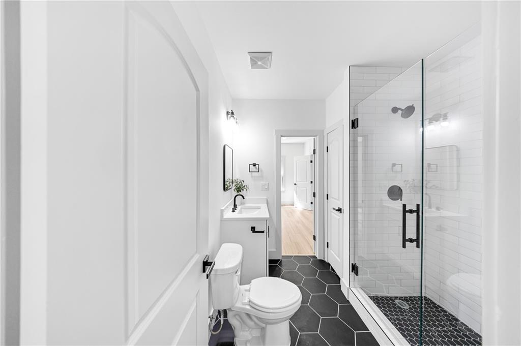 1749 Patriots Way Northwest Kennesaw, GA 30152 - Photo 44 of 54 a bathroom with a granite countertop toilet a sink and shower
