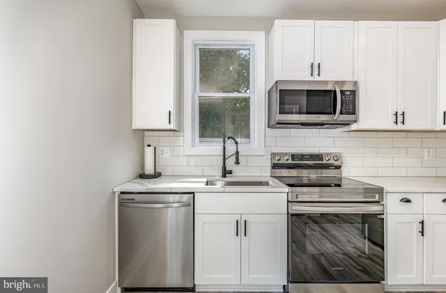 a kitchen with cabinets stainless steel appliances and sink