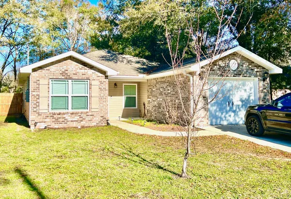 a view of a house with a yard and potted plants