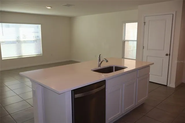 a kitchen with a sink cabinets and a window