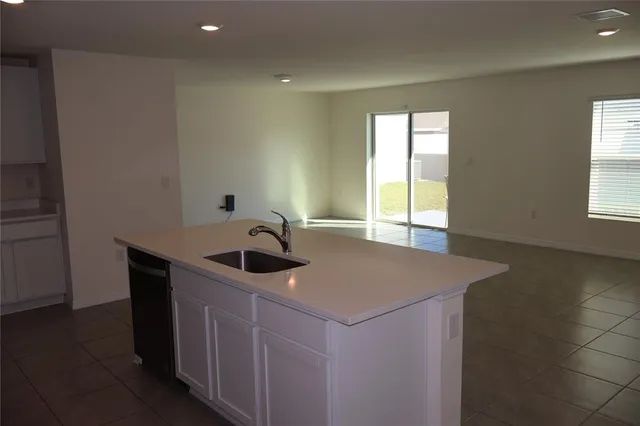 a kitchen with a sink a window and cabinets