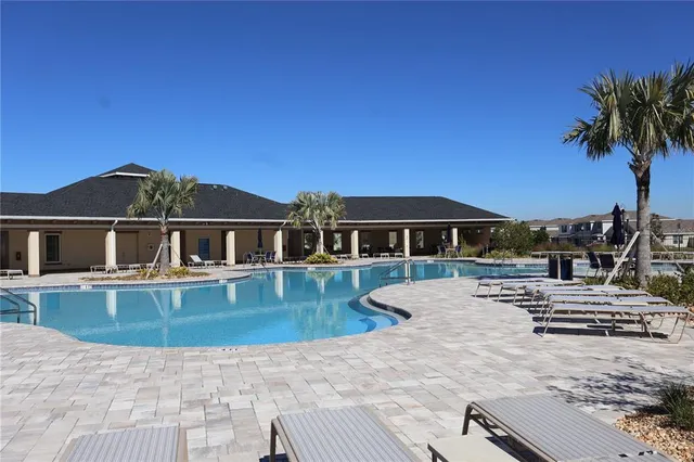 a front view of a house with garden and sitting area