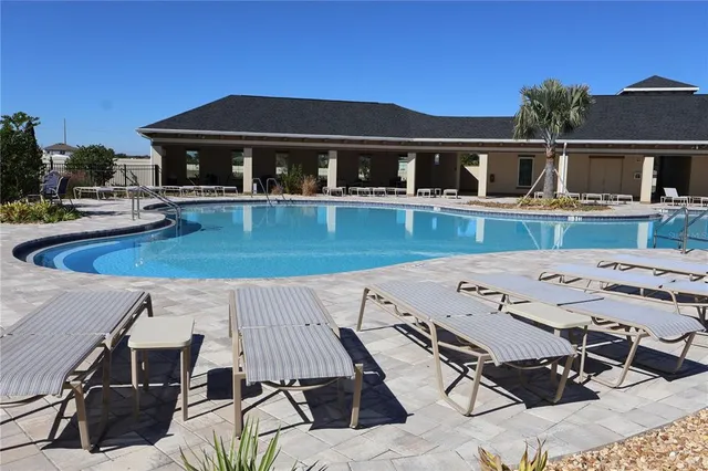 a view of house and patio with swimming pool