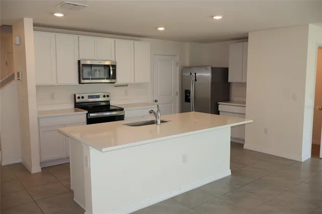 a kitchen with stainless steel appliances a refrigerator sink and microwave
