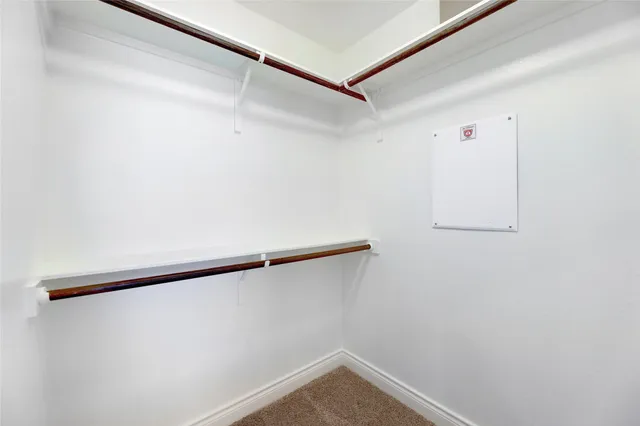 an empty room with wooden floor chandelier fan and windows