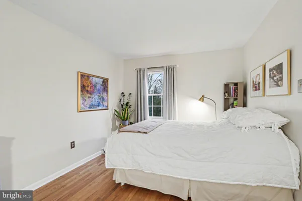 a large bedroom with a bed and wooden floor