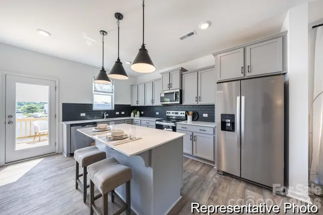 a kitchen with refrigerator cabinets and wooden floor